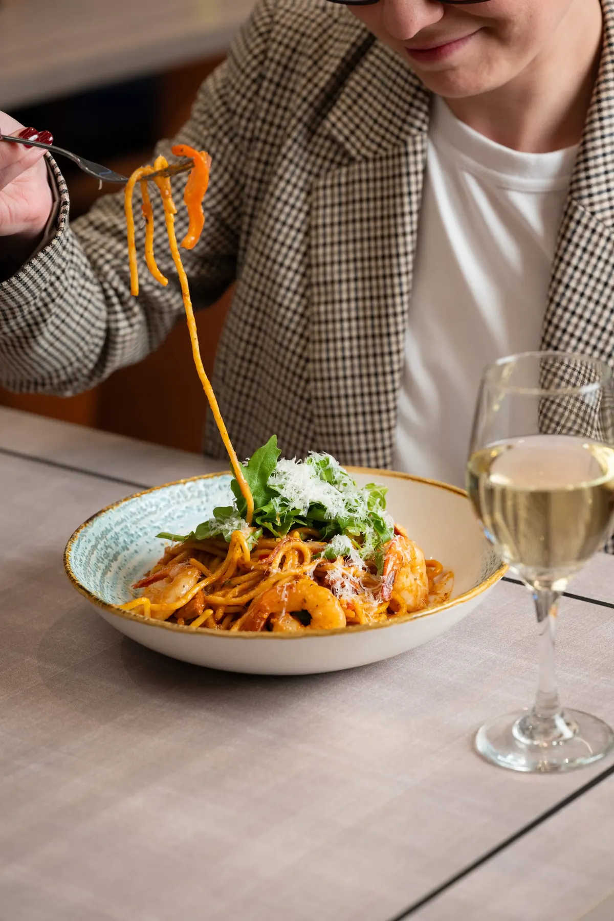 Guest twirling a forkful of pasta at the table
