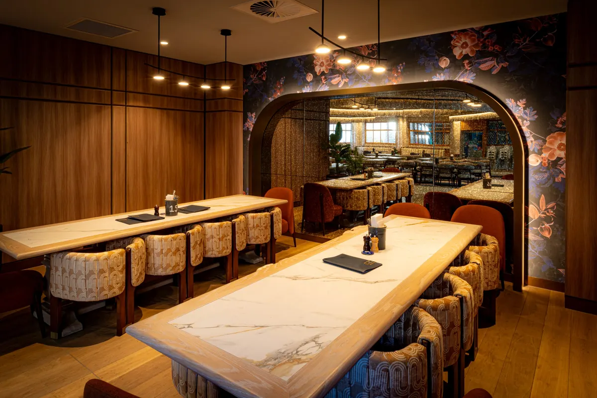 Timber-lined private dining room beneath a floral archway