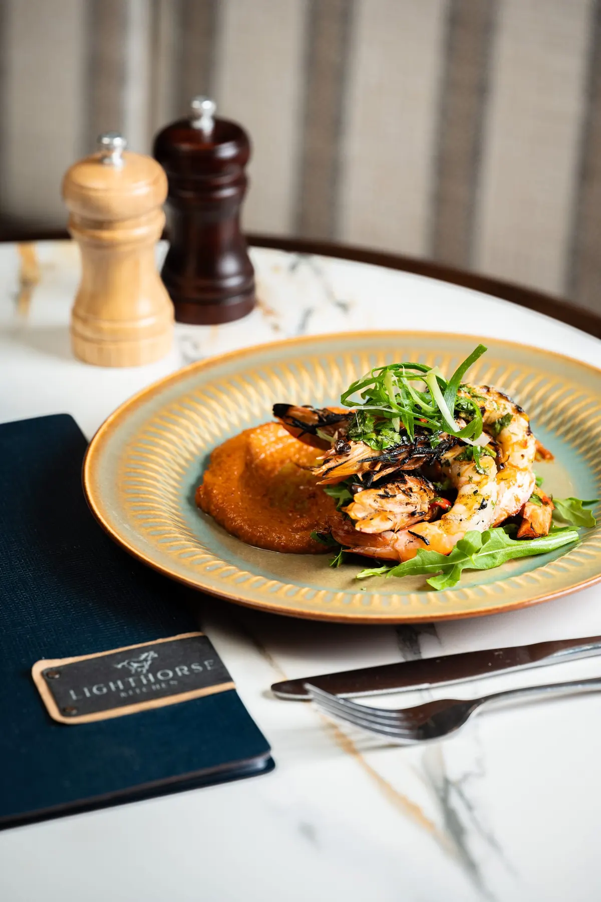 Chargrilled king prawns over a red pepper purée with herbs