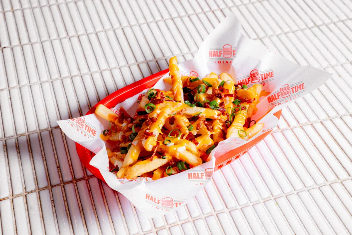 Loaded fries with bacon and cheese in a red diner basket
