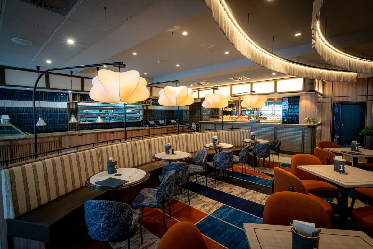 Bistro dining room with curved banquettes and paper pendant lights