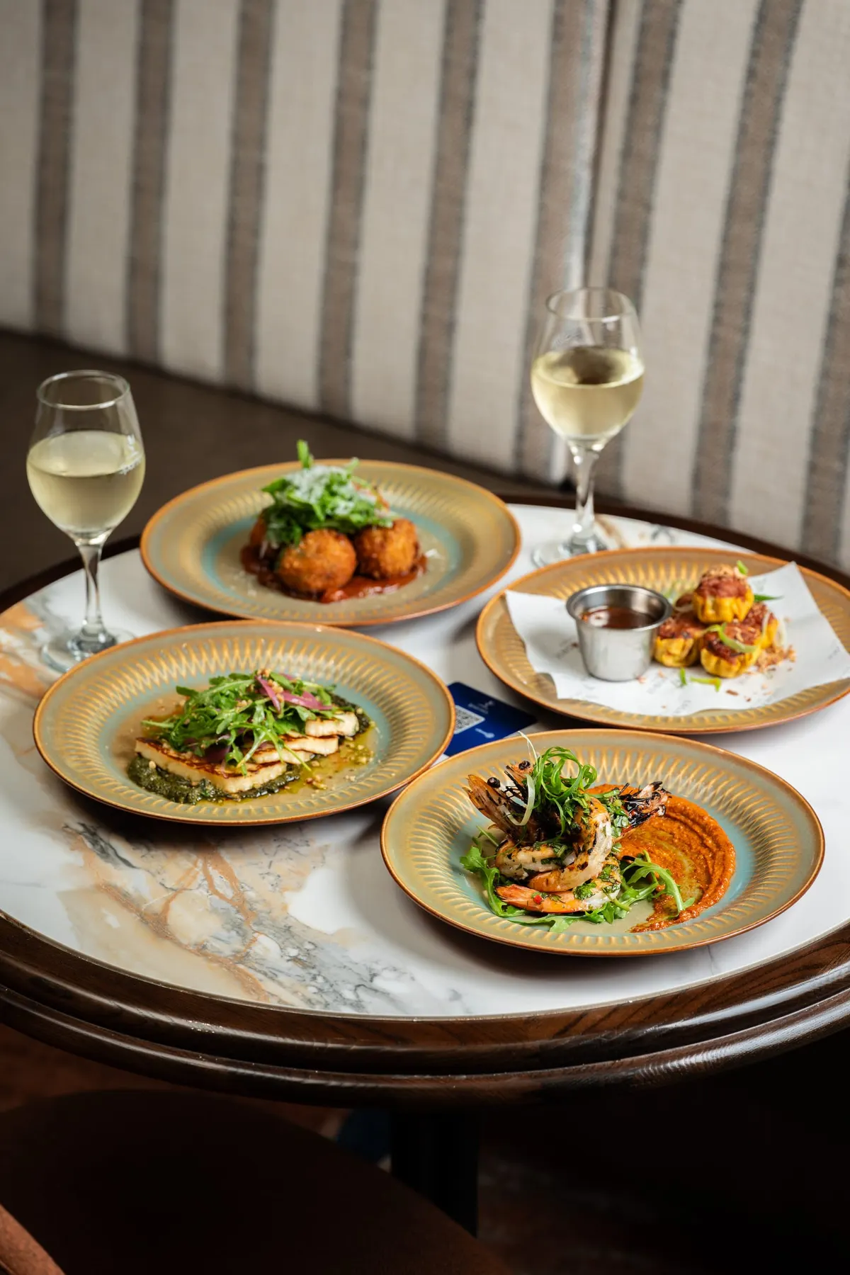 Several plated dishes shared across a marble table