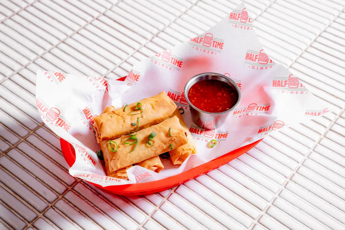 Spring rolls with sweet chilli sauce in a red basket