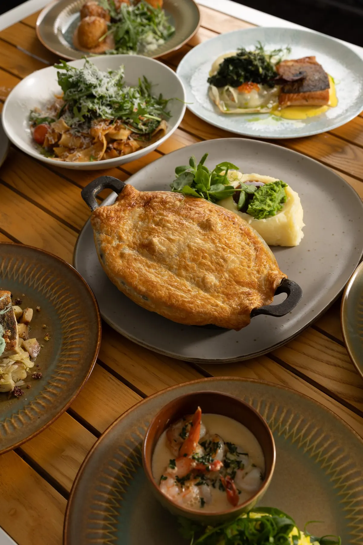 Shared table of pie, salads and small plates seen from above