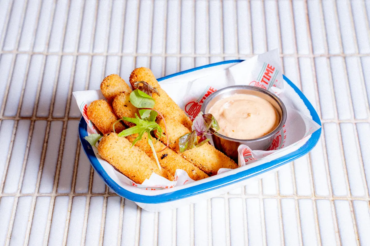 Mozzarella sticks with aioli in a blue enamel dish