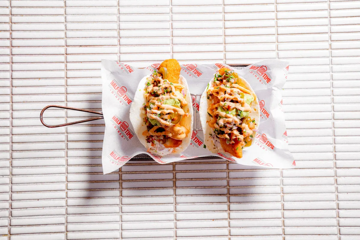 Two loaded hot dogs on a serving tray